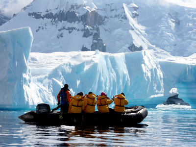 Zodiac-boot met reizigers langs een ijsberg in Antarctica tijdens de route Antarctica, vliegen en varen.