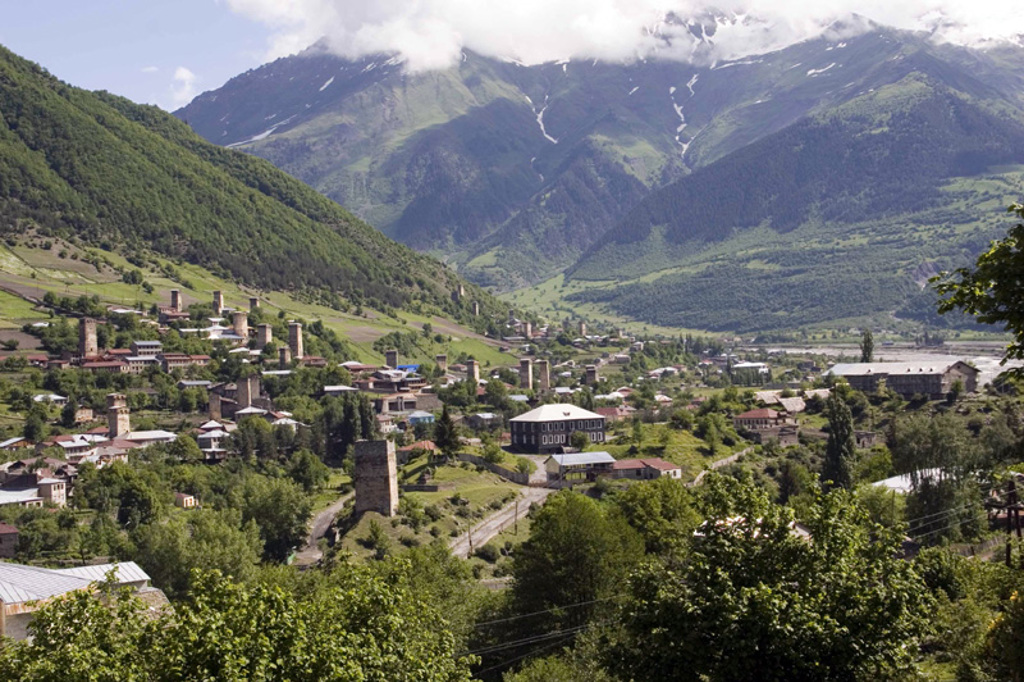 Panorama van bergdorp Mestia in Svaneti, Georgië, met middeleeuwse verdedigingstorens en besneeuwde bergtoppen.