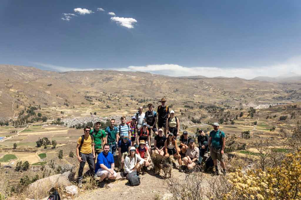 Groep 22-35ers tijdens rondreis Peru, poseren op uitkijkpunt met uitzicht over Andesvallei.