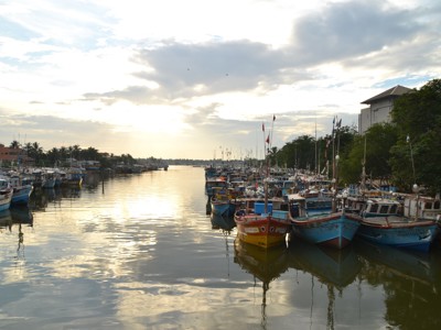 Vissersboten in de haven van Negombo bij zonsondergang, Route Sri Lanka.