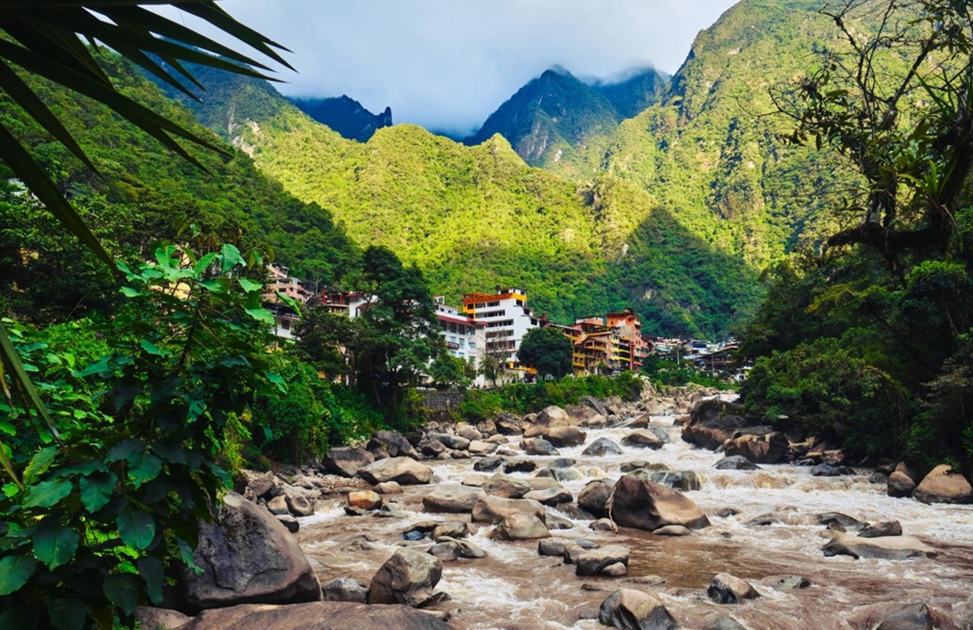Aguas Calientes aan de Urubamba-rivier met groene Andesbergen bij Machu Picchu, Peru.