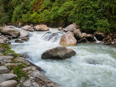 Wilde rivier met stroomversnellingen en grote rotsblokken langs de Route Nepal Annapurna.