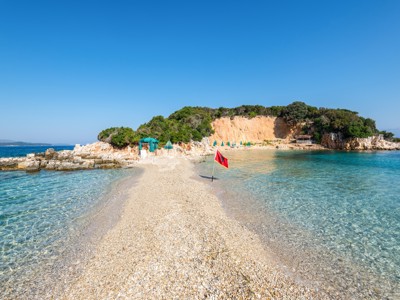 Kiezelstrand met smalle landtong en helderblauw water aan de Albanese Rivièra, Route Albanië.