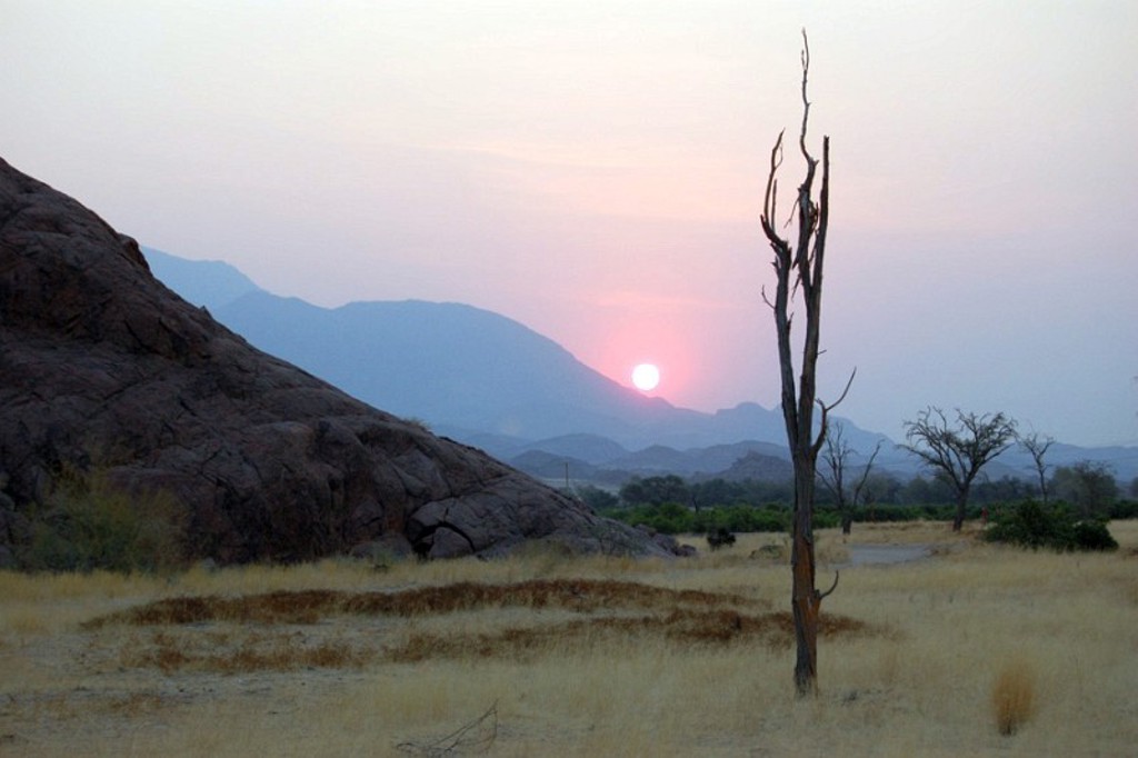 Zonsondergang boven rotslandschap en savanne in Zuidelijk Afrika tijdens een groepsrondreis.