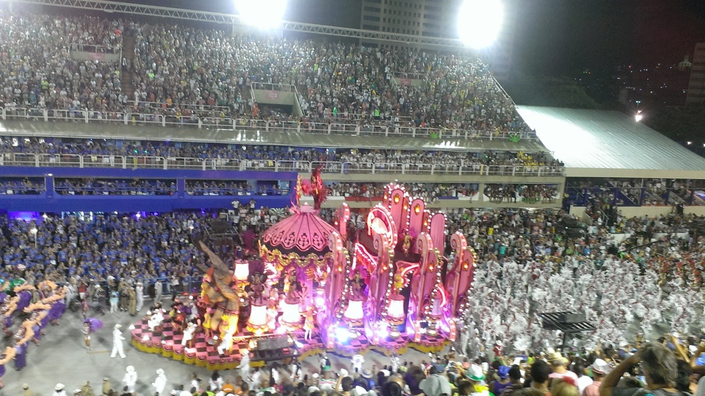Carnavalsoptocht in het Sambódromo in Rio de Janeiro met praalwagen en dansers voor volle tribunes.