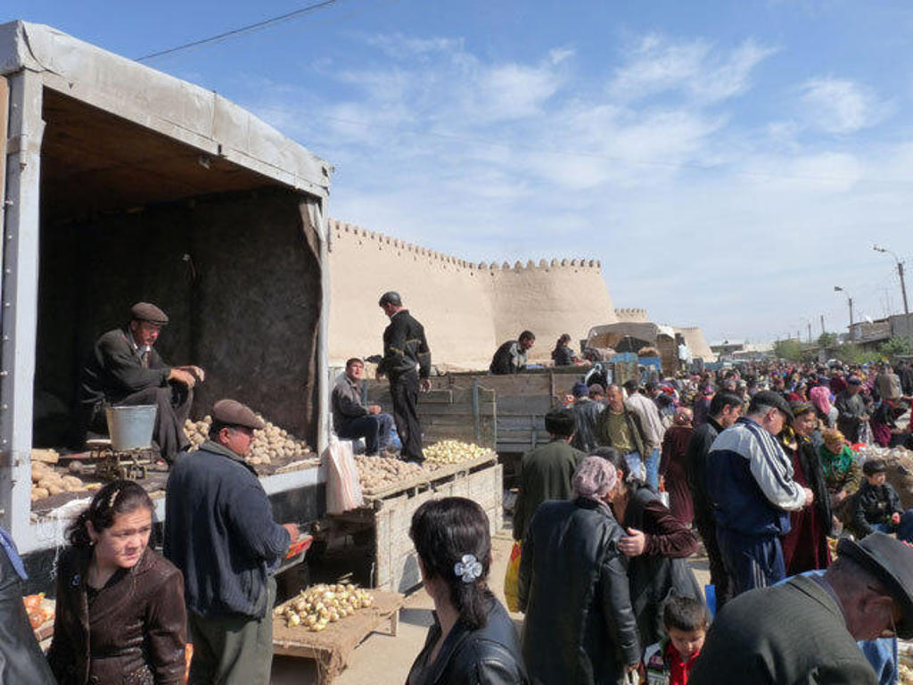 Drukke markt bij een stadsmuur in Oezbekistan tijdens een groepsrondreis Oezbekistan.