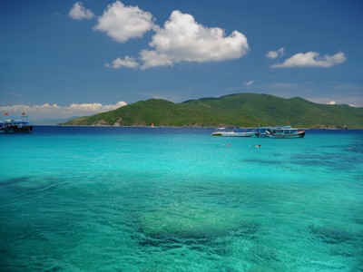 Turquoise zee met boten voor de kust van Nha Trang, Vietnam, tijdens de Route Vietnam.