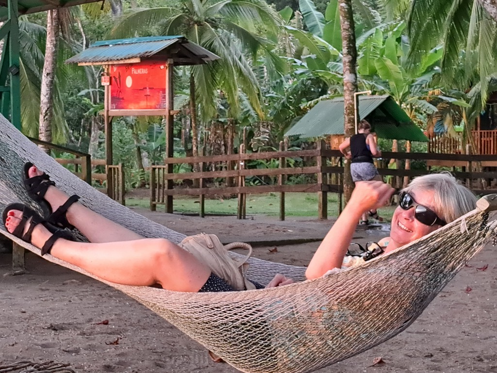 Reiziger ontspant in een hangmat tussen palmbomen tijdens groepsrondreis Costa Rica.