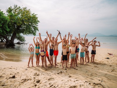 Groep gezinnen juicht op het strand in Thailand tijdens de 15-daagse familiereis Thailand Noord en Zuid.