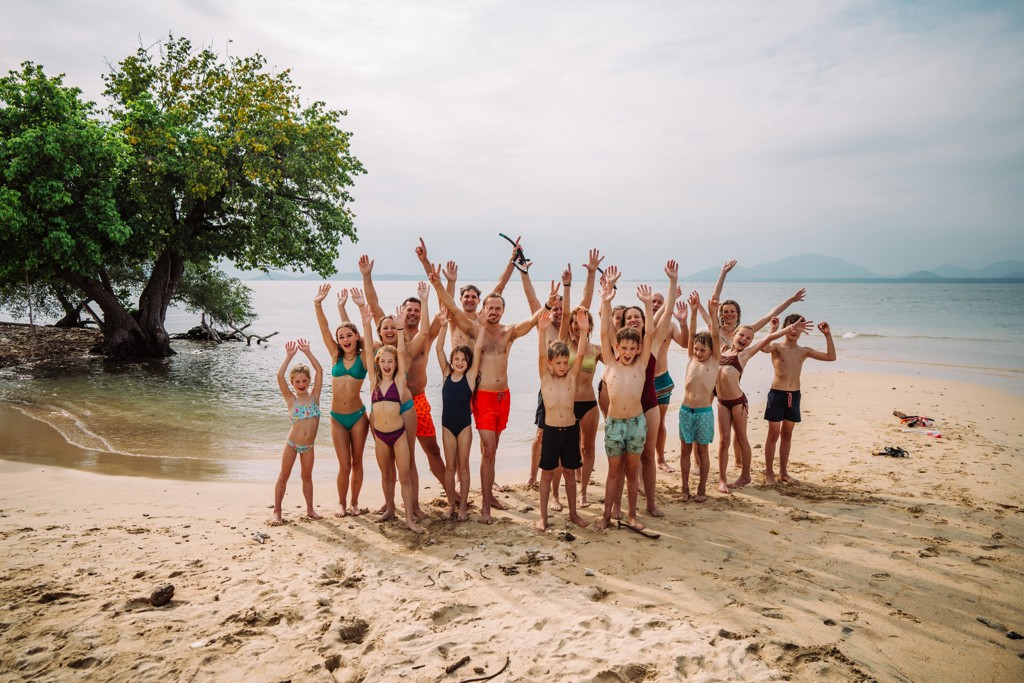 Groep gezinnen juicht op het strand in Thailand tijdens de 15-daagse familiereis Thailand Noord en Zuid.