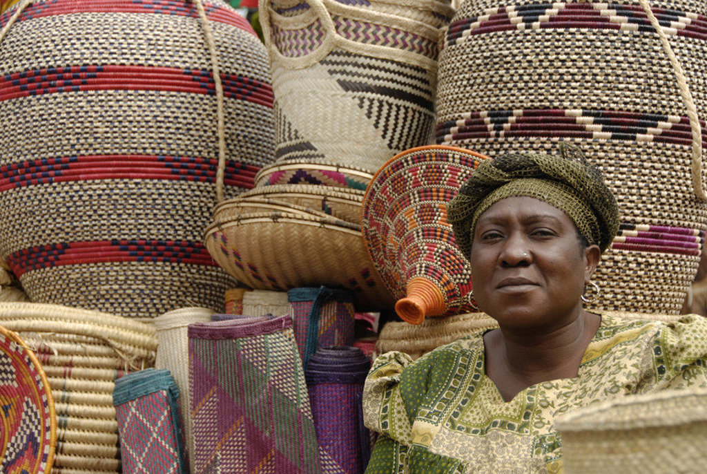 Vrouw op markt met kleurrijke gevlochten manden tijdens groepsrondreis Kenia en Tanzania.
