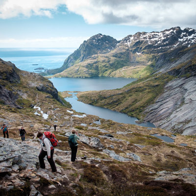 Wandelaars in berglandschap op de Lofoten, Noorwegen, met uitzicht op fjord en zee.
