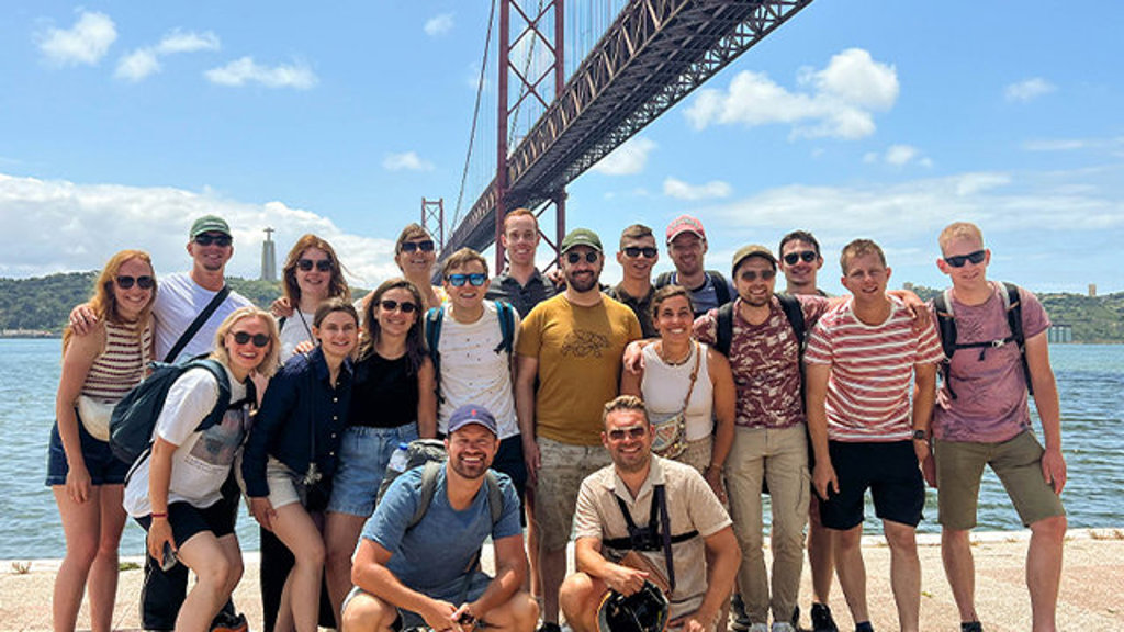 Groepsfoto van 22-35ers reis in Portugal bij de Ponte 25 de Abril in Lissabon.