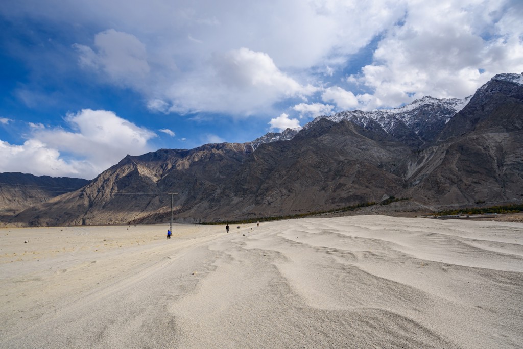 Zandduinen met uitzicht op ruige bergen in Baltistan, Pakistan.