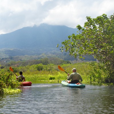 Kajakken door een rivier met uitzicht op een vulkaan tijdens de groepsrondreis Nicaragua en Costa Rica.