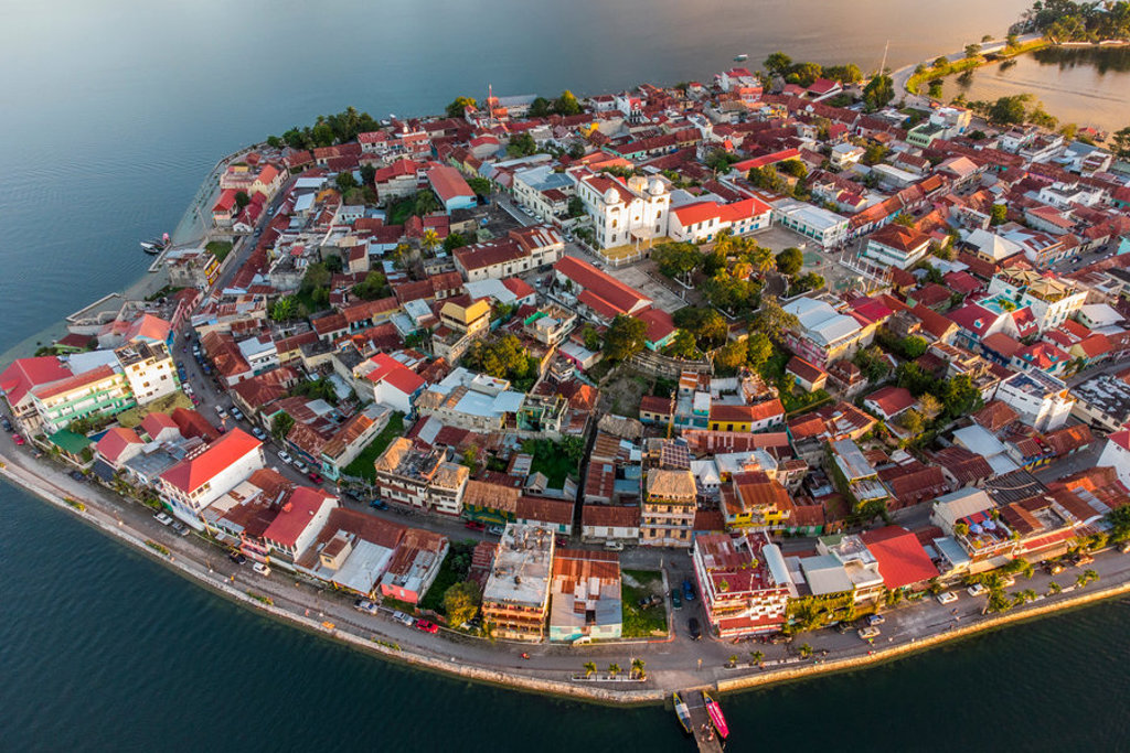 Flores aan het Petén Itzá-meer in Guatemala, met kleurrijke huizen en een witte kathedraal.