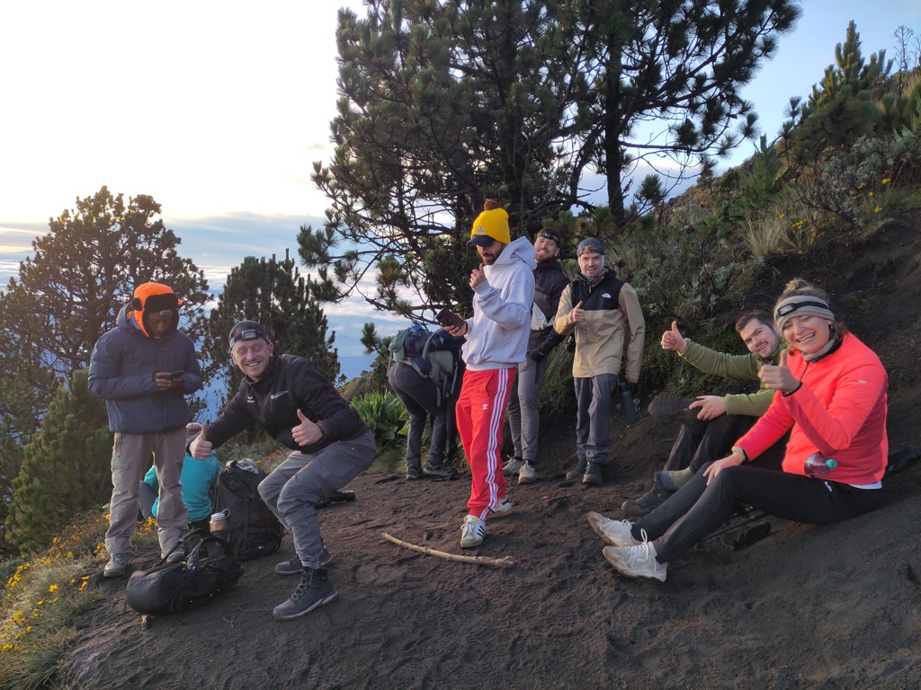 22-35ers groep rust uit tijdens vulkaanwandeling in Guatemala, met uitzicht boven de wolken.