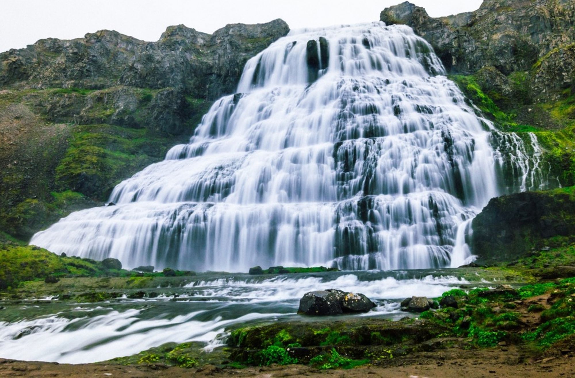 Brede waterval in IJsland die in meerdere terrassen over rotsen naar beneden stroomt.