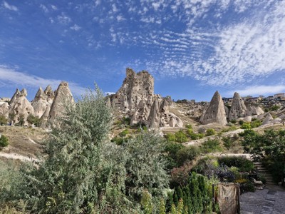 Uitzicht op rotsformaties en uitgehakte grotwoningen in Cappadocië, Turkije, onder een helderblauwe lucht.
