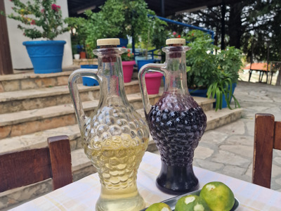 Twee karaffen met lokale wijn en citrusvruchten op een terras tijdens de wandelreis op Cyprus.
