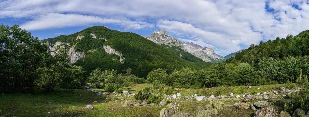 Groene bergvallei met rotsachtige Peaks of the Balkan, ideaal voor een wandelvakantie in Albanië.