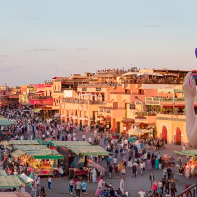 Toerist fotografeert het drukke plein Jemaa el-Fna en de markt in Marrakech tijdens een familiereis Marokko.