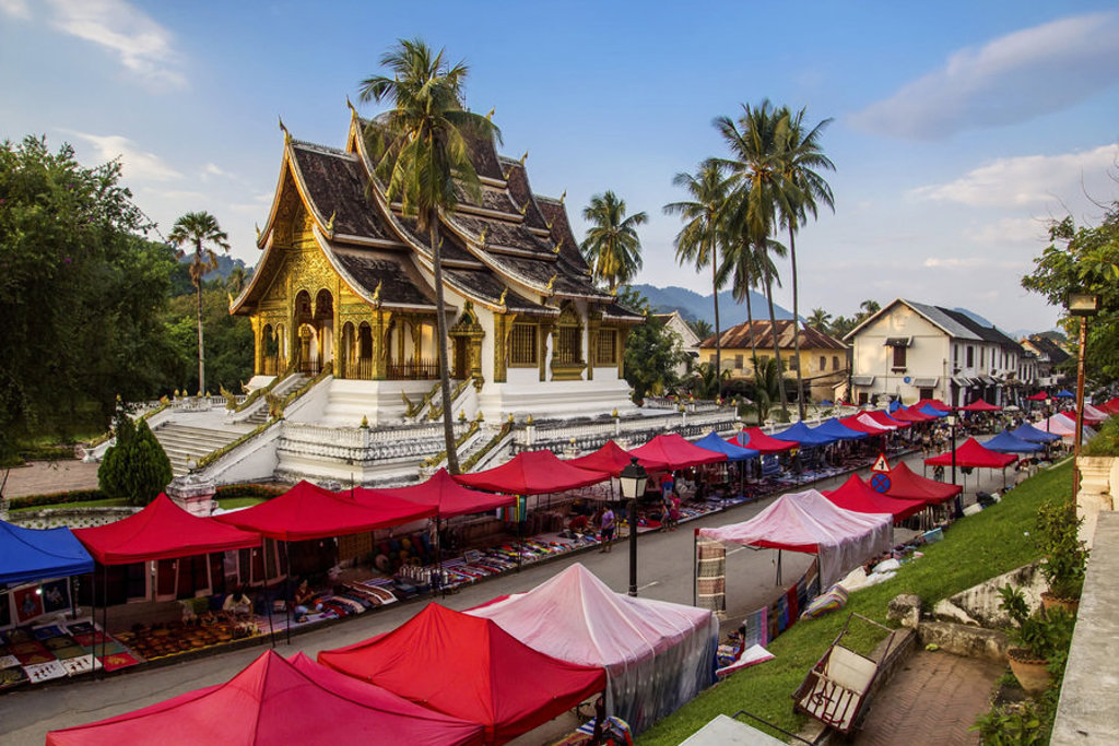 Gouden tempel in Luang Prabang met kleurrijke avondmarkt, tijdens familiereis Thailand, Laos en Cambodja.