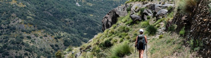 Wandelaar met rugzak op bergpad in Andalusië tijdens een wandelvakantie met Sawadee.