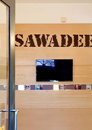 Reisbureau Sawadee met balie en wanddecoratie in het kantoor.