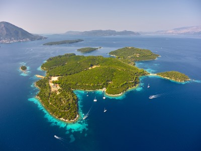 eiland Skorpios in Griekenland met groene heuvels, turquoise baaien en zeilboten.