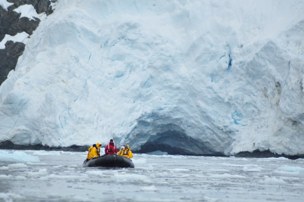 Zodiacboot met reizigers bij een ijswand in Antarctica tijdens de groepsrondreis naar de Poolcirkel.