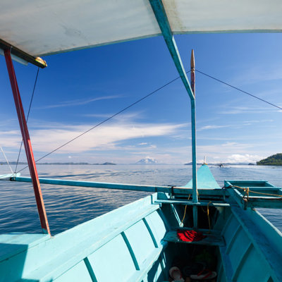 Uitzicht vanaf een boot tijdens Port Barton island hopping, met kalme zee en groene eilanden onder blauwe lucht.