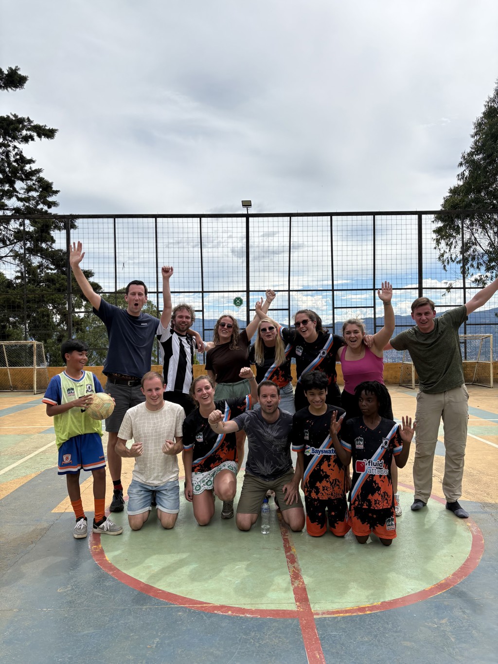 Groepsfoto van 22-35ers reis Colombia na een potje voetbal op een sportveld.