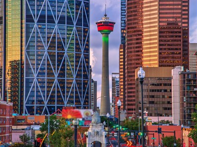 Skyline van Calgary met de Calgary Tower tussen moderne wolkenkrabbers tijdens zonsondergang.