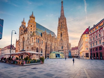 Fietsers op een fietspad langs de Donau met uitzicht op historische gebouwen en kerktorens.