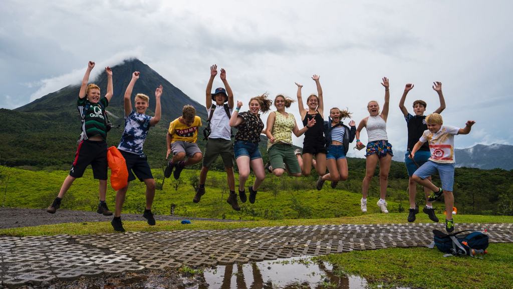 Kinderen zweven aan een zipline tussen de boomtoppen in Costa Rica tijdens een familiereis.