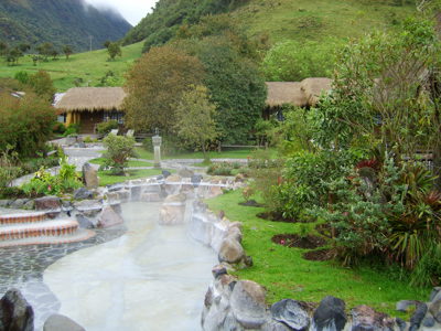 Thermale baden in Papallacta, Ecuador, met stoom, rotspartijen en groene bergen op de achtergrond.