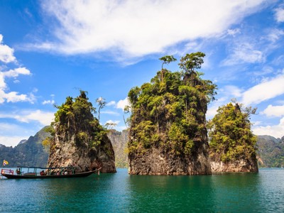 Longtailboot op het Cheow Lan-meer bij kalksteenrotsen in Khao Sok National Park, Thailand.