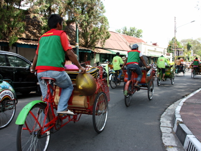 Fietstaxi’s (becaks) in de straat van Yogyakarta tijdens de route Java en Bali.