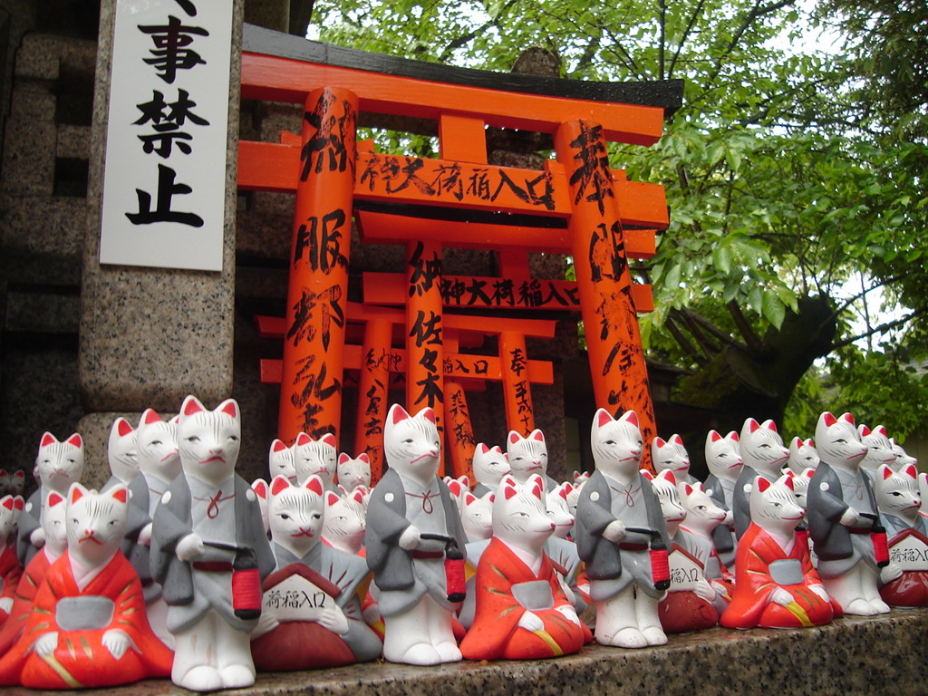 Rode torii-poorten en vossenbeeldjes bij een Japanse tempel, Familiereis Japan.
