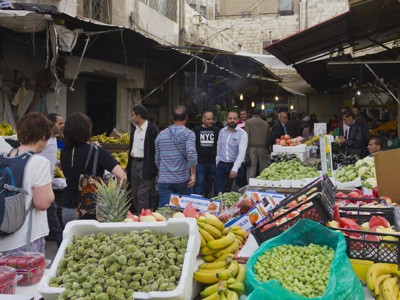 Drukke markt in Jordanië met kraampjes vol vers fruit en groente.