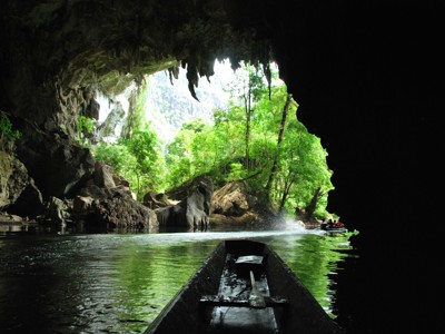 Boottocht door een grot met groen rivierlandschap tijdens de Route Laos & Cambodja.