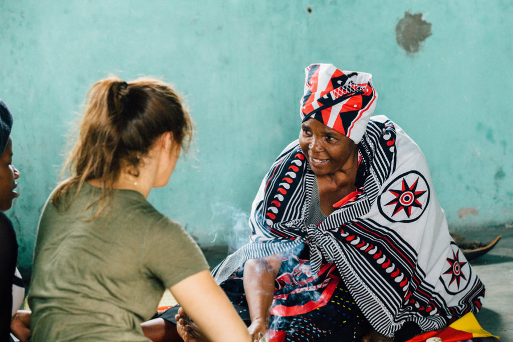 Vrouw in traditionele kleding praat met reiziger tijdens 22-35ers reis Zuid-Afrika.
