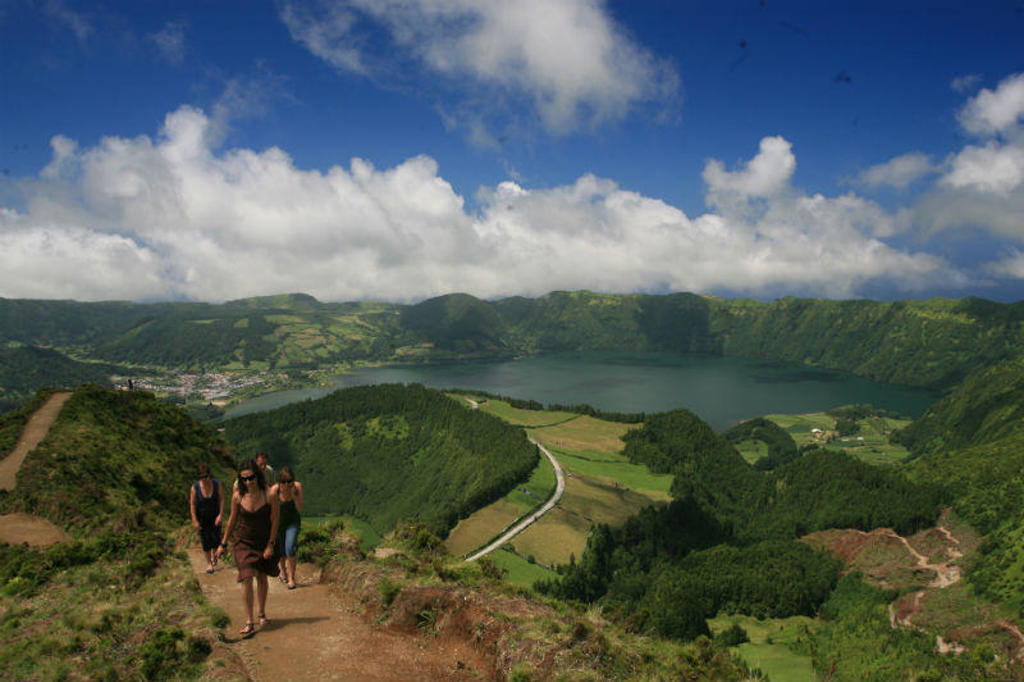 Wandelaars op bergpad met uitzicht op Lagoa das Sete Cidades op São Miguel, Azoren.