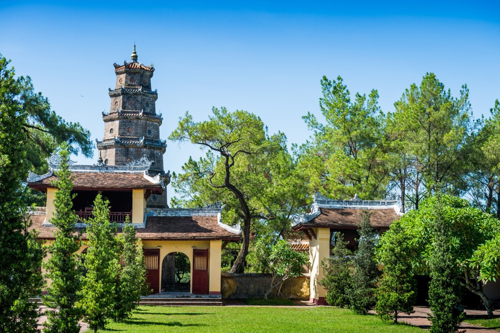 Thiên Mụ-pagode in Hué, Vietnam, met toren en tempelgebouwen tussen groene bomen.