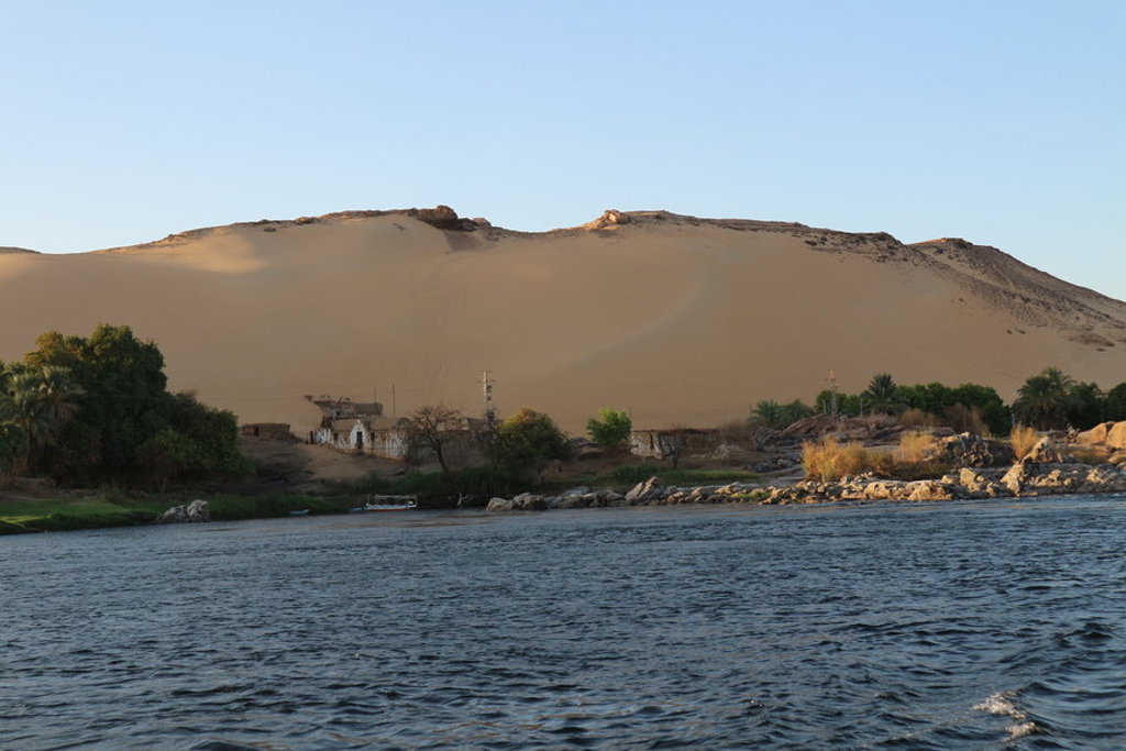 Nijl met palmbomen en zandduinen langs de oever tijdens de groepsrondreis Egypte Hoogtepunten.