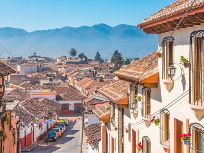 Uitzicht over de kleurrijke daken van San Cristóbal de las Casas in Mexico, met bergen op de achtergrond.