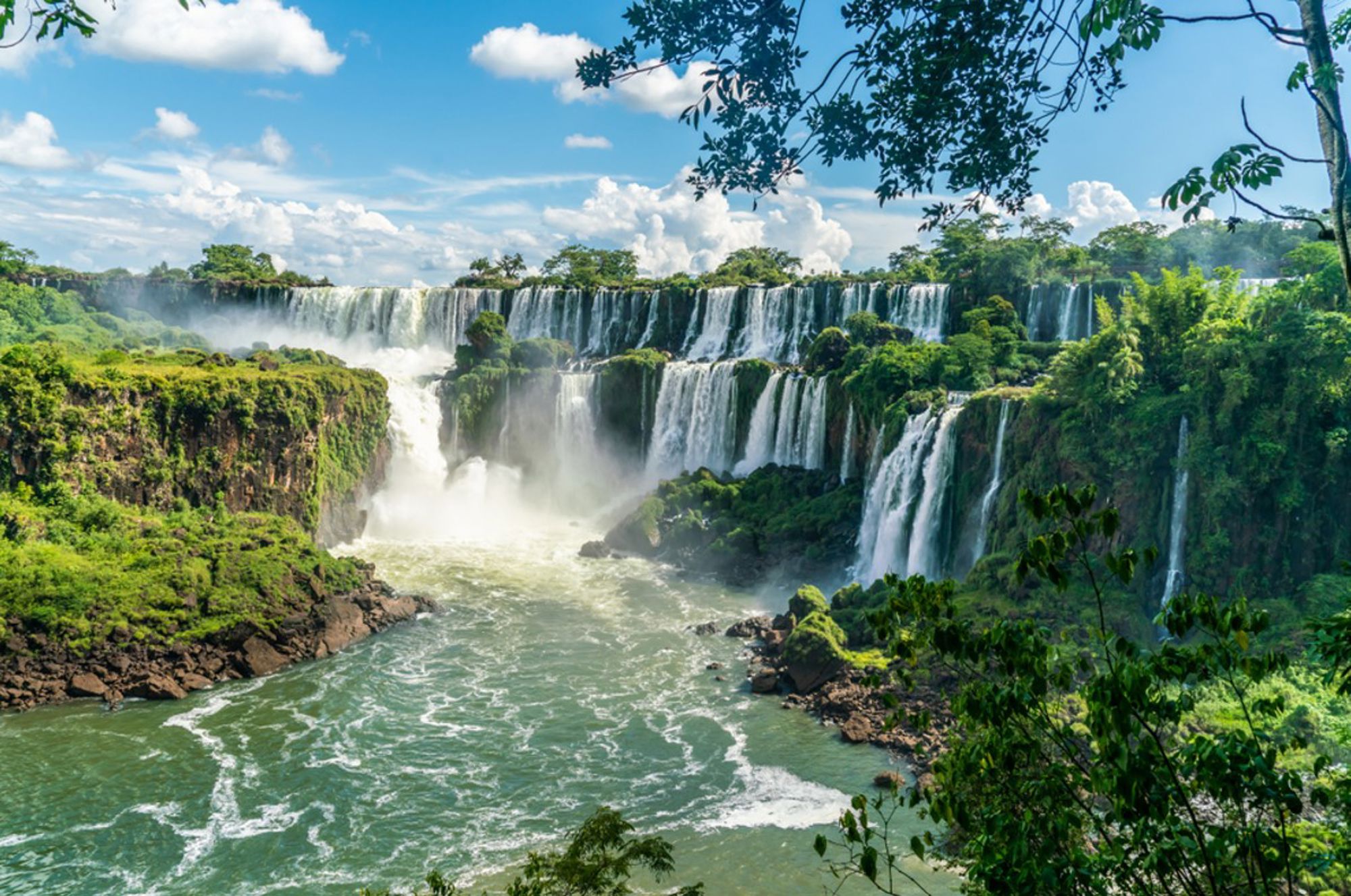 Panoramisch uitzicht op de Iguazú-watervallen in Brazilië, met meerdere watervallen en groene jungle.