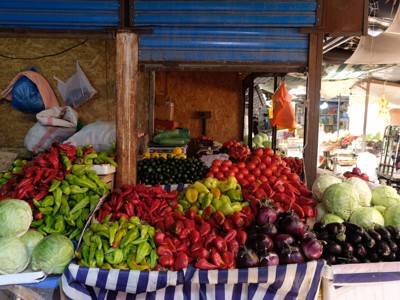 Marktkraam met verse groenten zoals paprika’s, tomaten, kool en aubergines langs de Zijderoute.