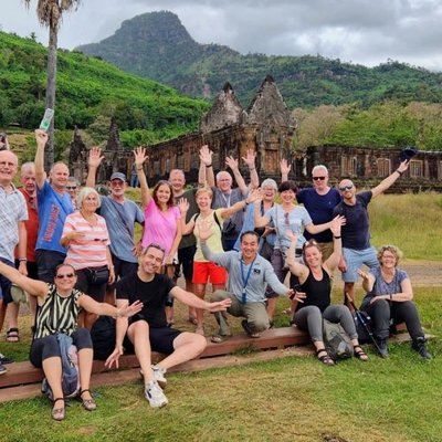 Monniken lopen langs een tempelcomplex tijdens een groepsrondreis door Laos en Cambodja.